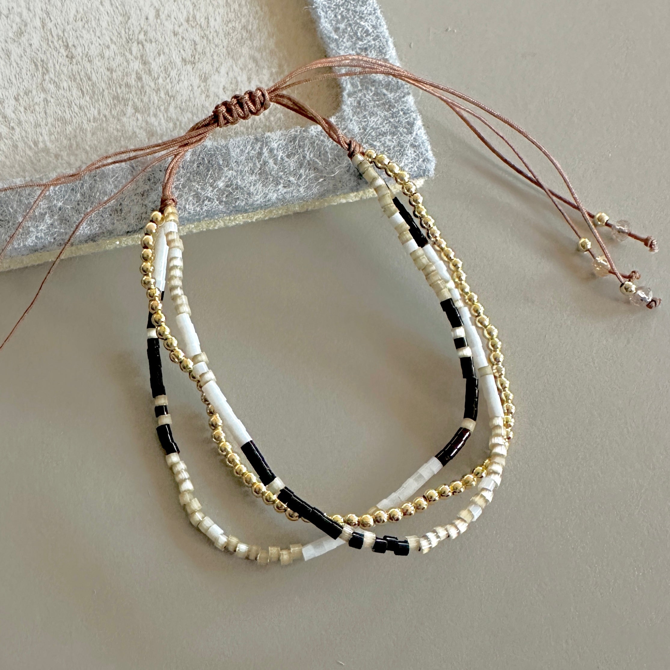 PULSERA TRIPLE NEGRO BEIGE Y DORADO | LUNAM