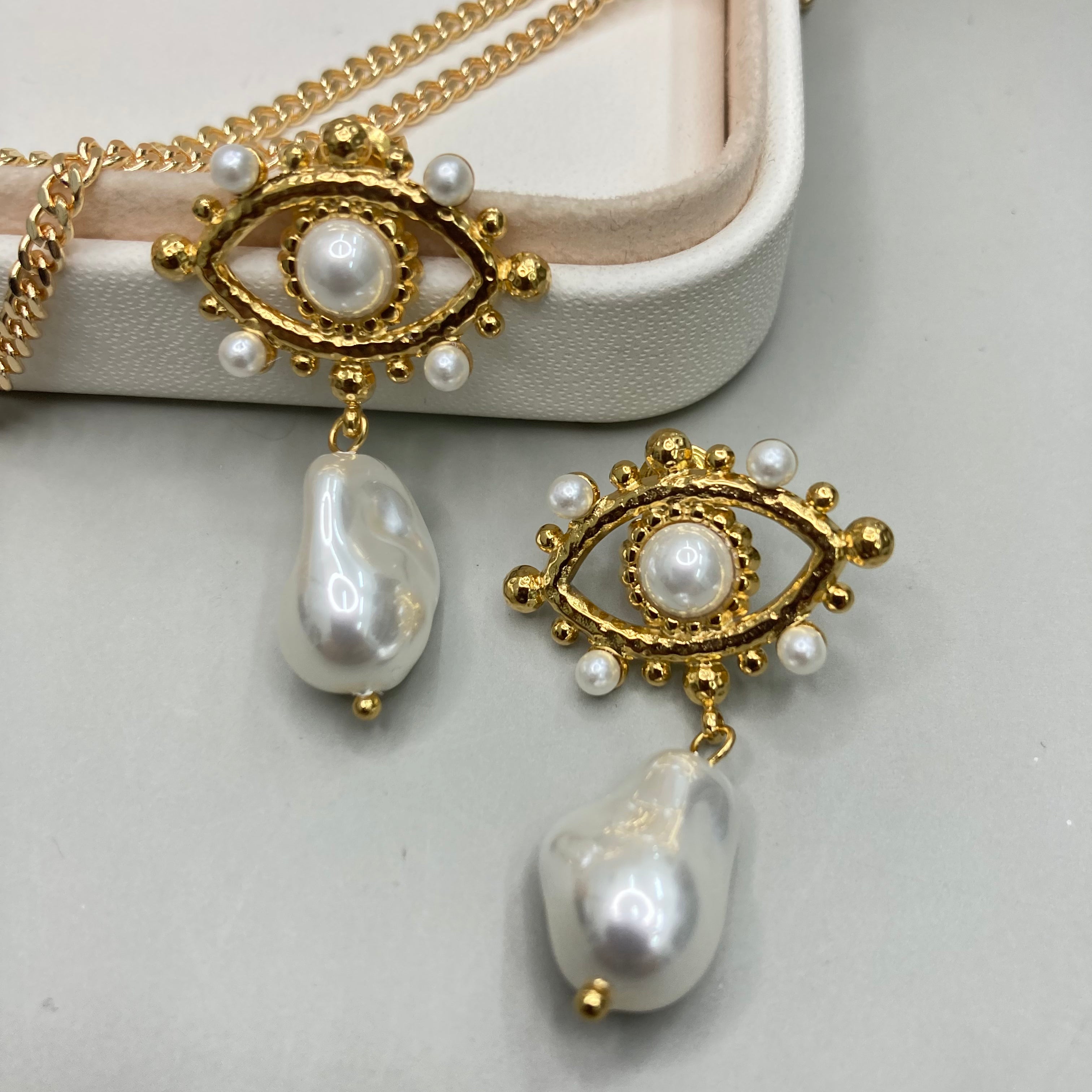 AROS | DISEÑO DE OJO CON PIEDRAS Y PERLA COLGANTE