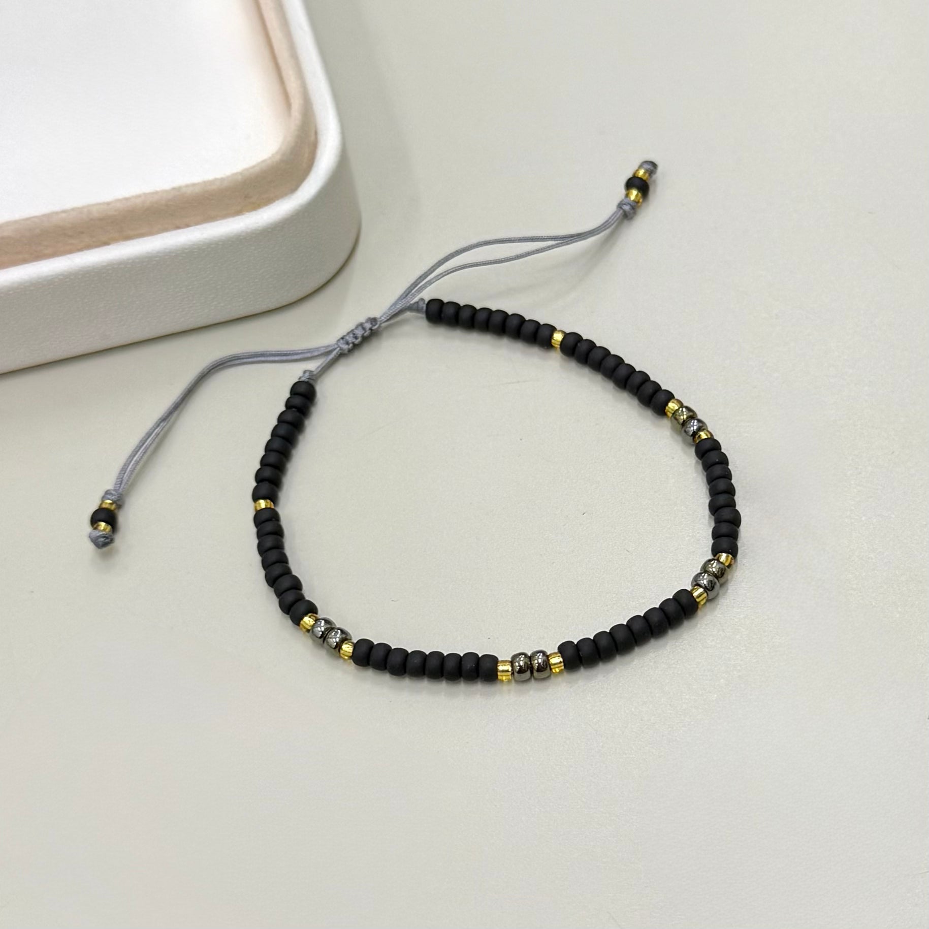 PULSERA NEGRO GRAFITO Y DORADO | LUNAM