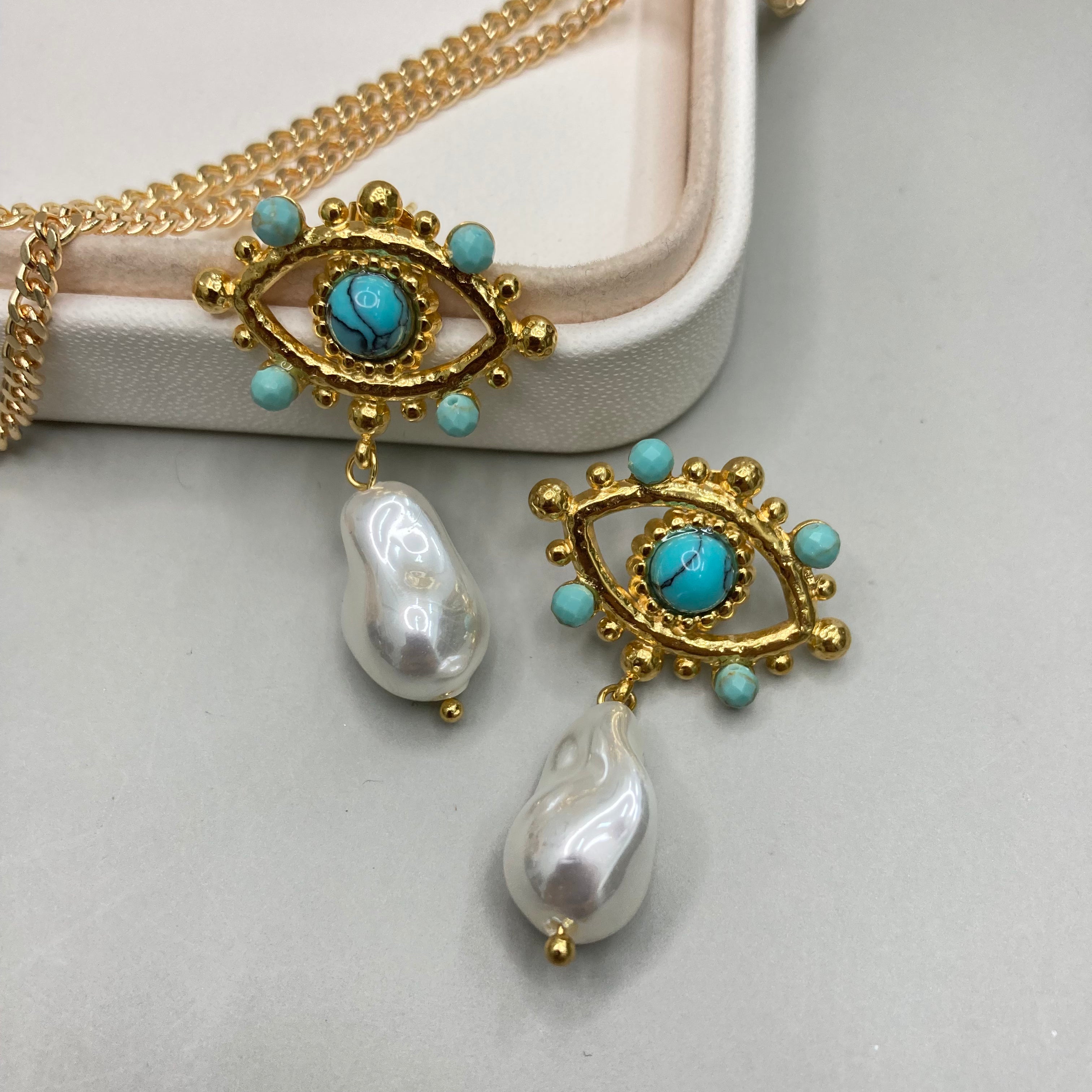 AROS | DISEÑO DE OJO CON PIEDRAS Y PERLA COLGANTE